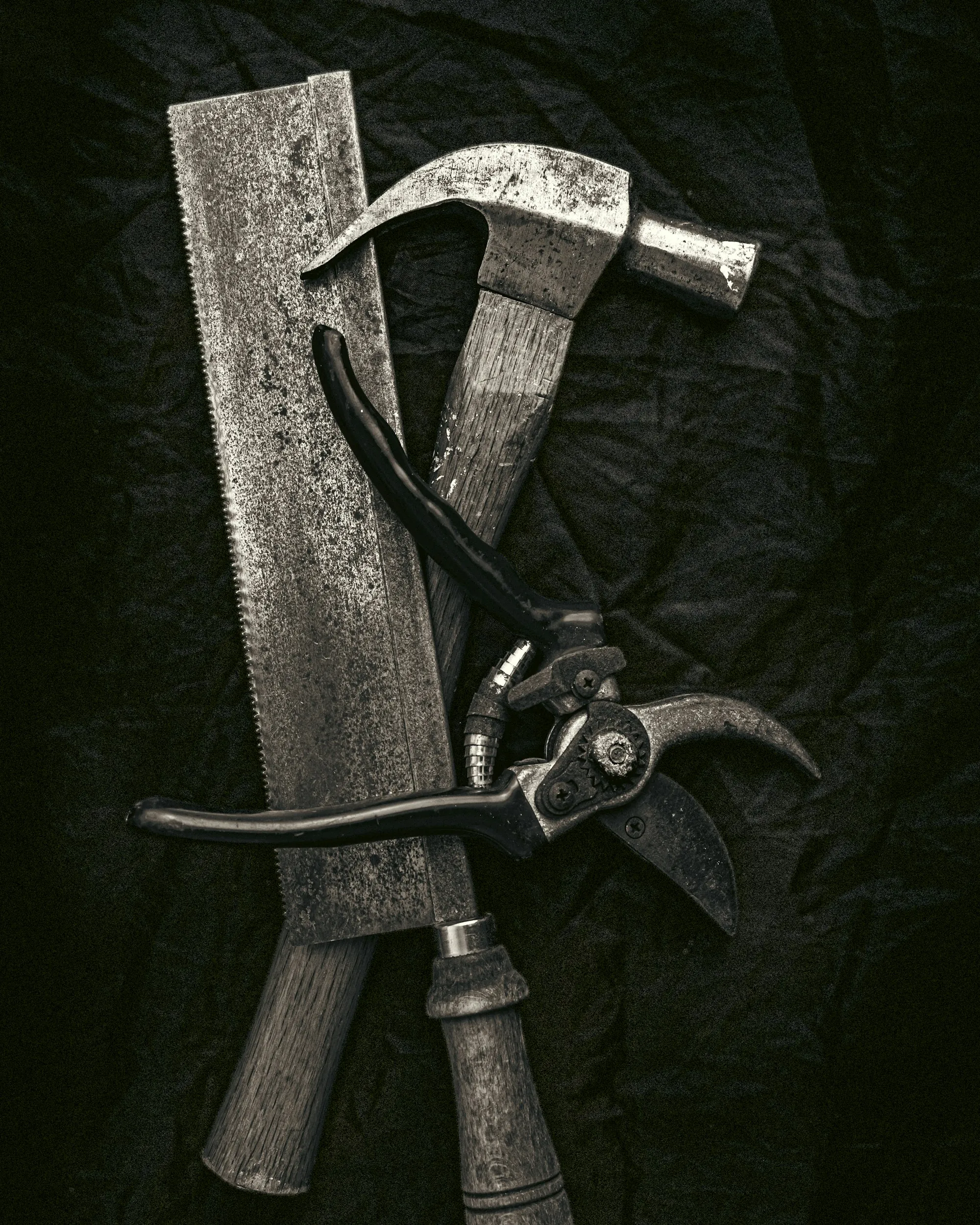 Saw and pliers on a dark background